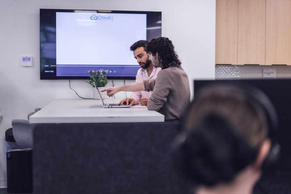 Two coworkers working on a laptop