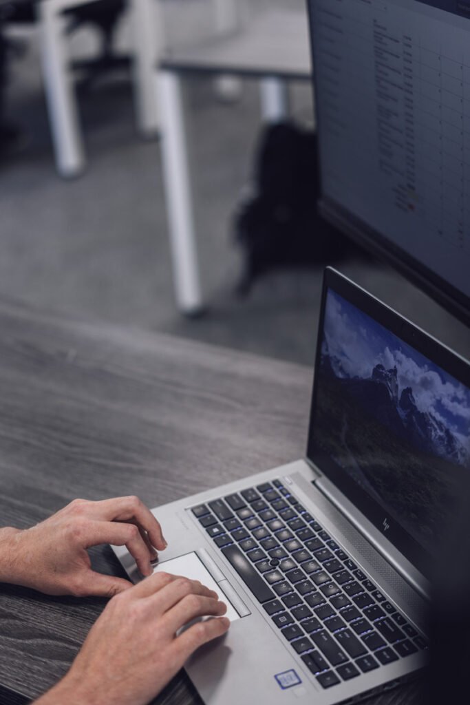 Two hands typing on a laptop