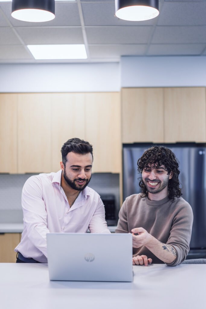 Two coworkers looking at a laptop